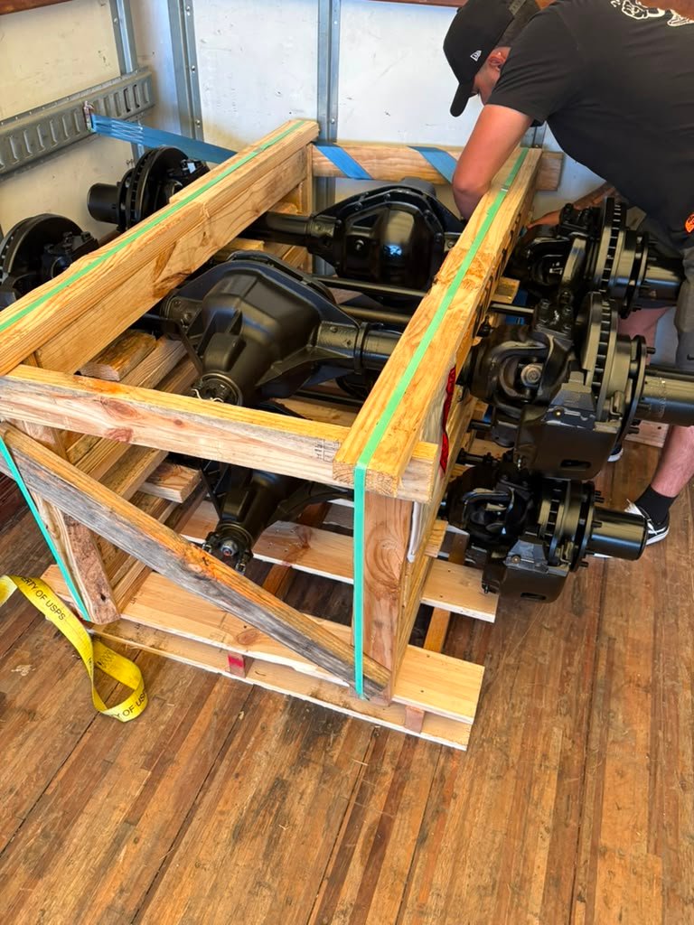 Ejes y componentes transportados en caja de madera
