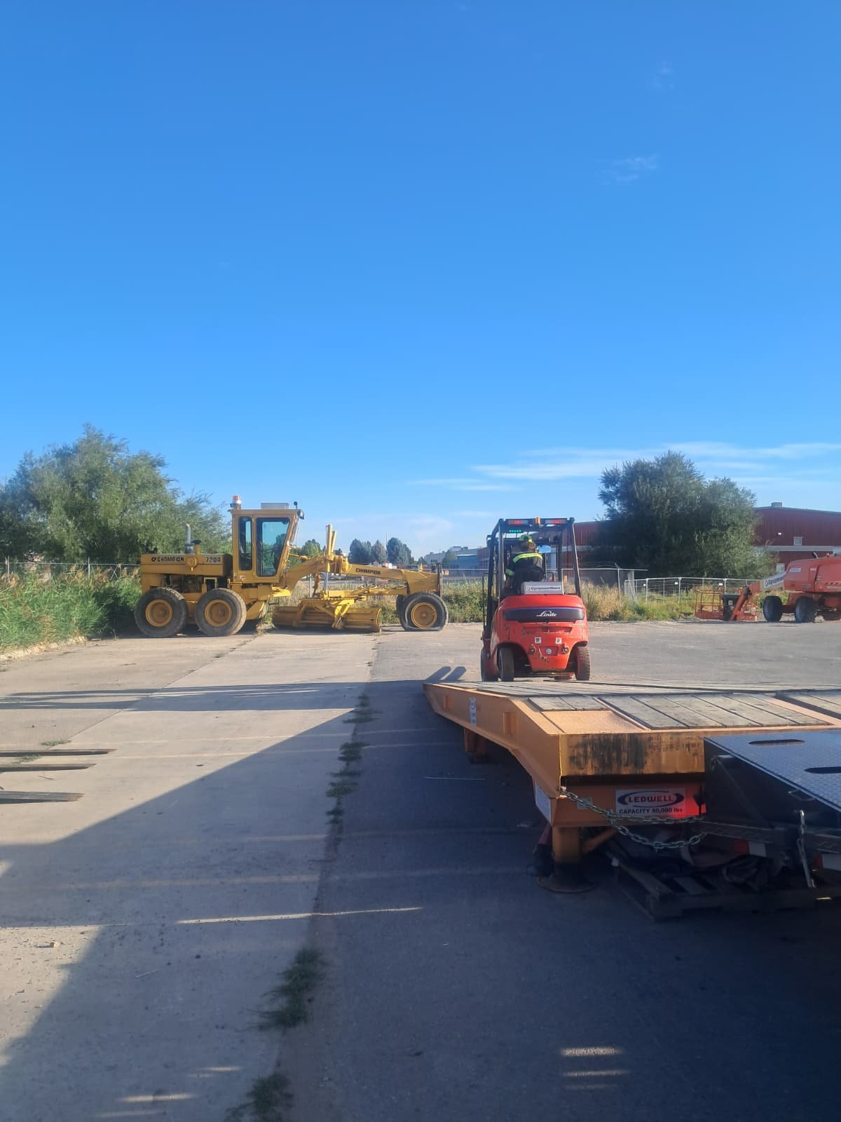 Montacargas acercándose a un remolque de plataforma durante una operación de carga