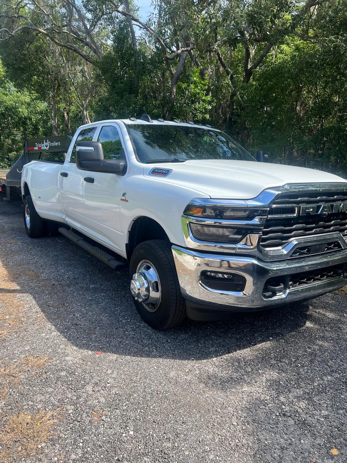 Camión RAM 3500 blanco con remolque de plataforma