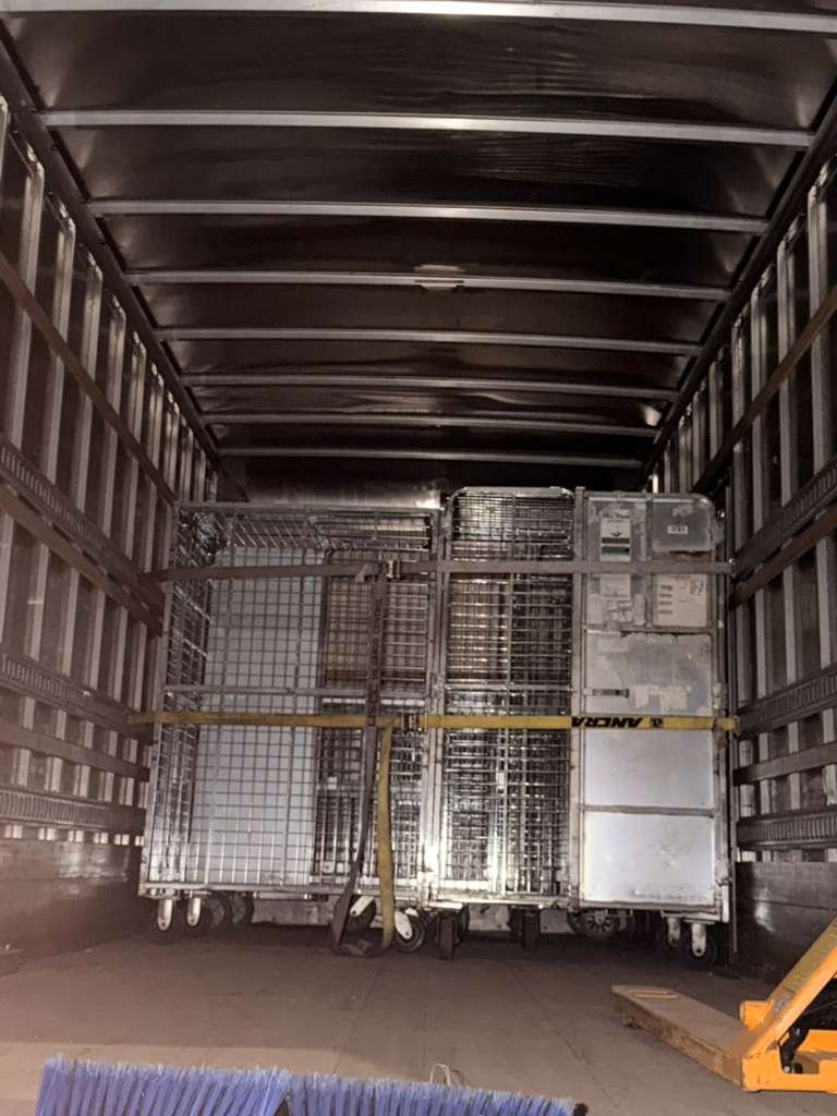Carros metálicos asegurados dentro de un camión para transporte de devolución
